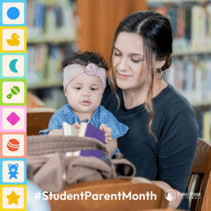 A woman holds a toddler while reading to her at a library.