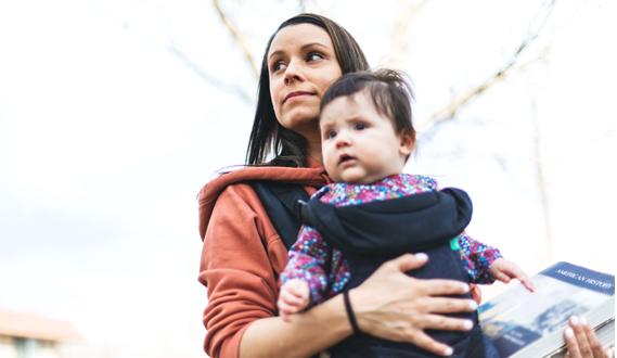 A mom holds a baby in carrier