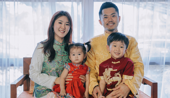 A Chinese family with 2 young children poses in festive attire.