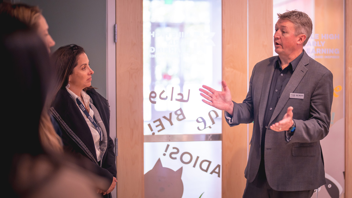 Tour attendees talk by the entrance of Tamara M. Sparks Early Learning Center at Mile High United Way