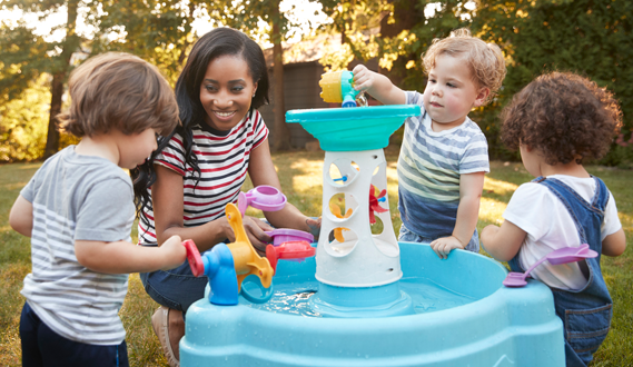 Preschoolers play with a water table with their in-home daycare provider.