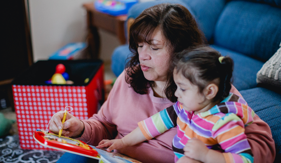 An in-home provider plays with a young girl.