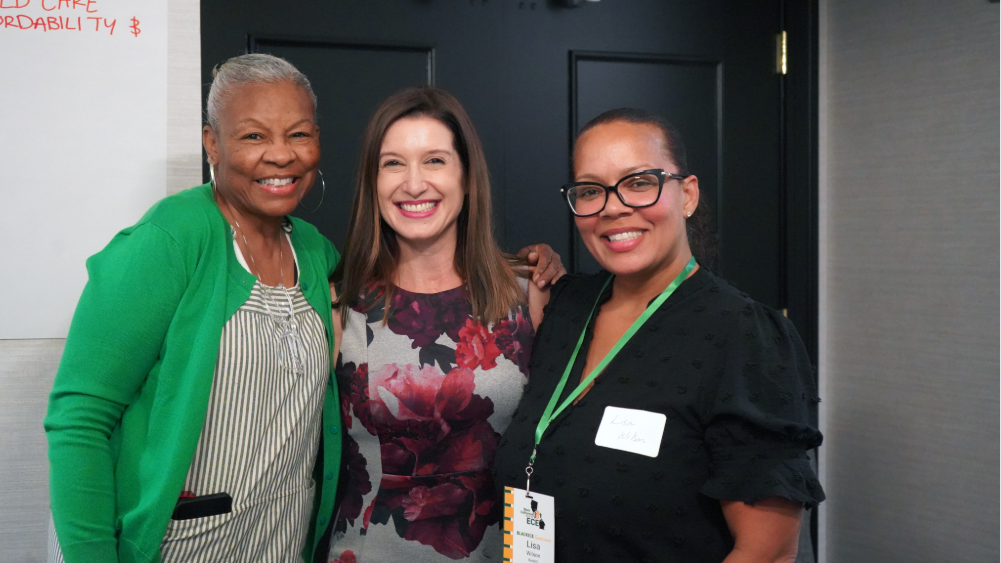 3 attendees including Carolyne Crolotte pose for a picture.