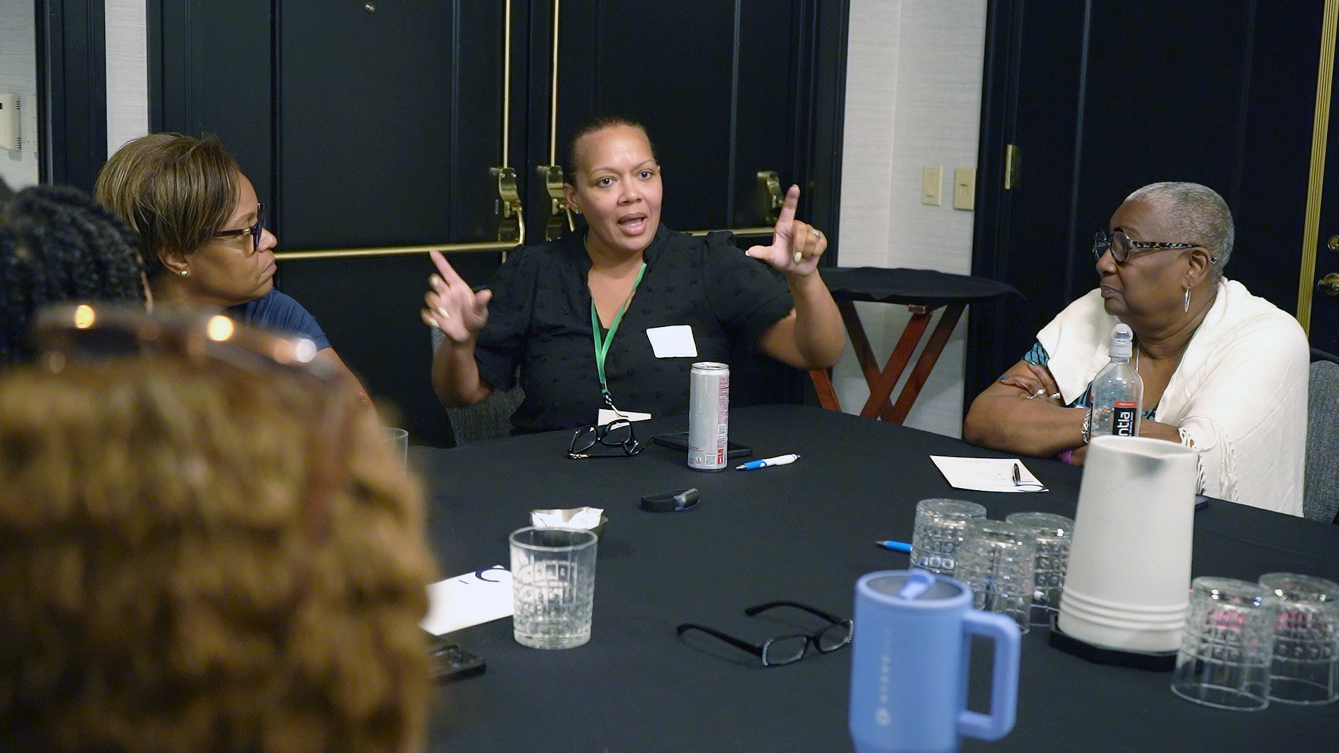 An attendee speaks while gesturing like she is measuring something.