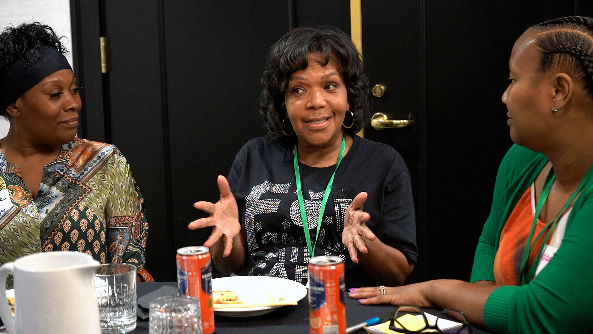 An attendee gestures with her hands as she speaks.