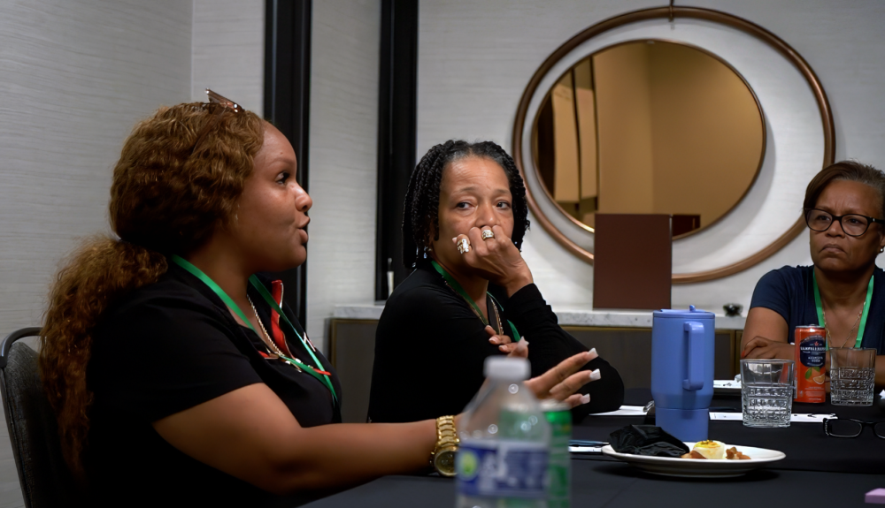 An attendee looks on as another speaks.